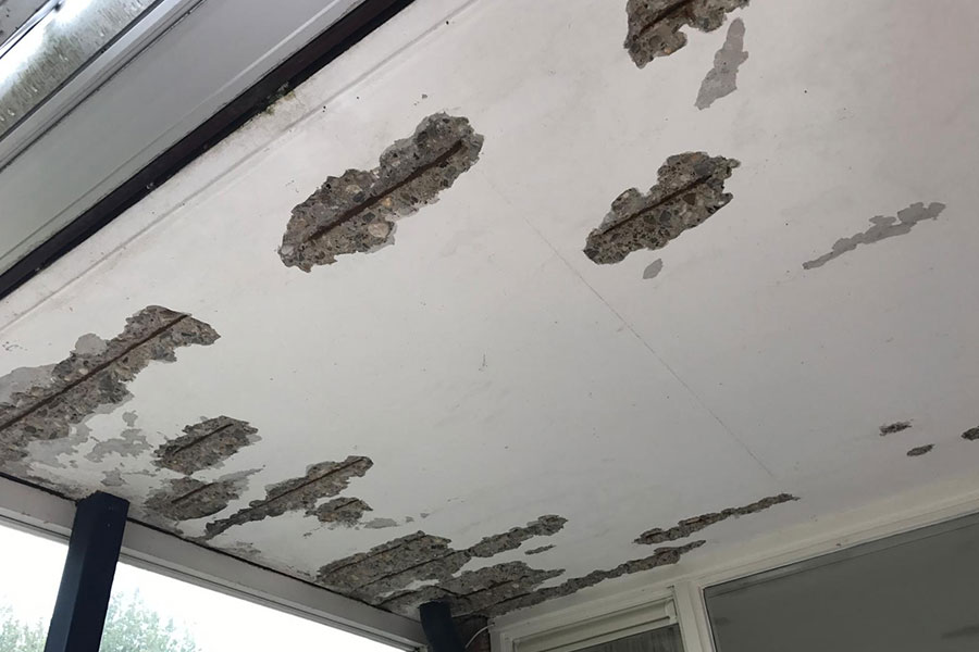 Voorbeeld van betonrot en herstelwerk in een pand